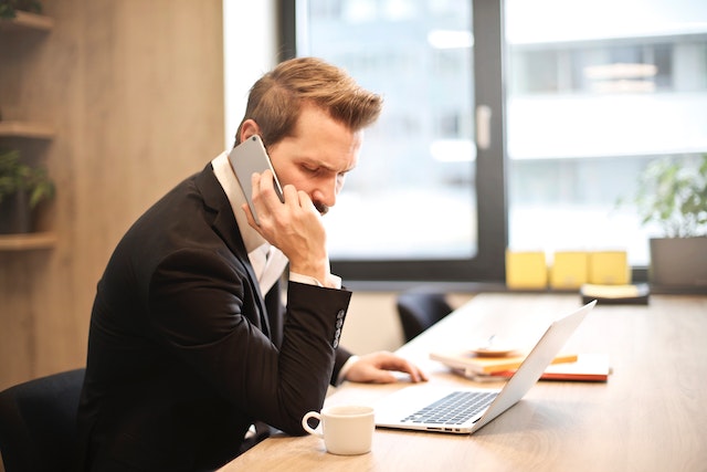 A property manager in a black suit tells a client about the resuts of a tenant screening